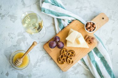 Peynir tabağı ile üzüm, bal, kraker ve fındık ahşap bir tabakta servis