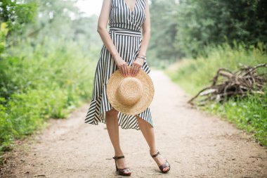 hasır şapka elinde tutan kız