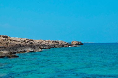 turkuaz deniz arka plan üzerinde kayalık kıyı şeridi 