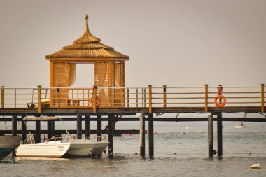 deniz üzerindeki iskelede şezlong ile özel ahşap çardak görünümü  