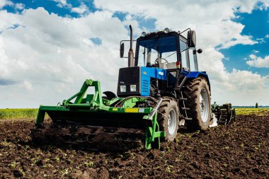 Traktör alanında çalışır.
