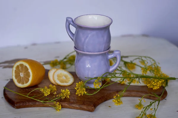 Óvatosan lila tál alakú egy Bud, borított jegesedés. A készség a keramikus. A sárga vadvirágok, fából készült tábla. Reggel, a faluban. Limon — Stock Fotó