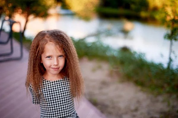 The baby is 4 years old, with blue eyes and small curls. Childrens enjoyment of life and adventures. Warm Golden sunset light. Sly eyes, with a squint — Stock Photo, Image