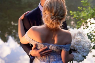 Damat gelini su romantik bir parkta sarılmak. Düğün yürüyüş