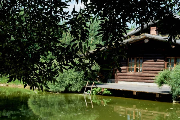 Huis aan het water. Dorpshuis log in de buurt van het meer. Rest van de stad, vissen, jacht. Dorp hut — Stockfoto