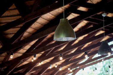 Ahşap bir çadır, tavandan asılı lambalar Teras. Açık veranda aydınlatma