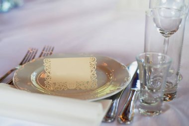 Klasik masa ayarı. Aletleri, Gözlük, beyaz masa örtüsü ve plaka, plaka üzerinde bir adla bir kart