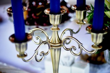 Altın beş-boynuzun mumluk mavi mum ile. Yakından