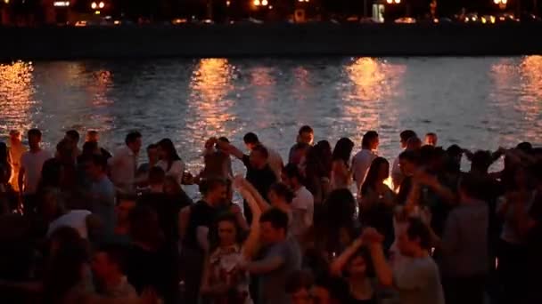Moscou, Rússia-29 de junho de 2018: Noite quente de verão no Gorky Park durante a FIFA 2018.As pessoas dançam perto do rio Moscou, perto da ponte Alexander à beira-mar — Vídeo de Stock