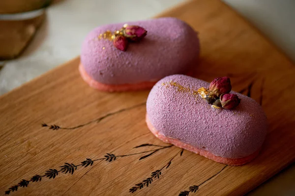 Beautiful fruit mousse cake lilac on a wooden Board with pattern