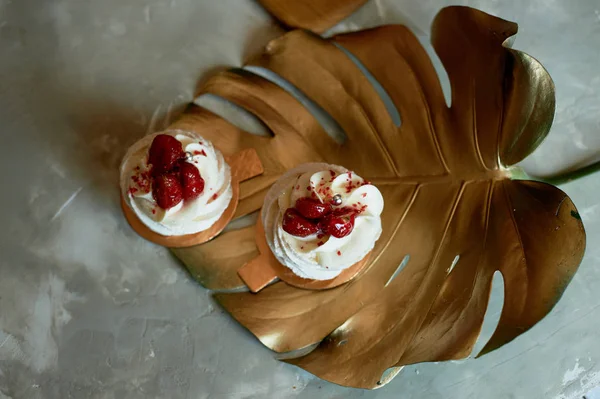 Meringue aérienne et délicieuse Anna Pavlova sur une feuille d'or monstera.Art culinaire — Photo