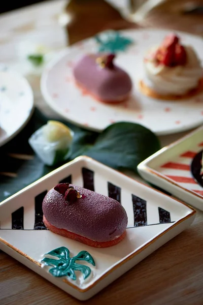 Fruit mousse cake and meringue Anna Pavlova on beautiful saucers.Culinary art.