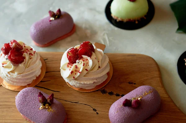 Purple fruit mousse cake, meringue Anna Pavlova on a wooden Board.Culinary art