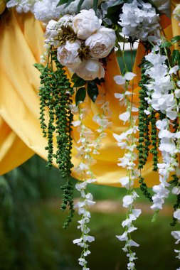 Arch Sarı kumaş ve çiçeklerle süslenmiş açık havada düğün töreni için. Ayrıntılar kapatın