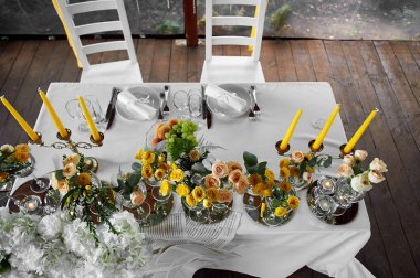 Tablo gelin ve damat, gözlüklü bir şekilde dekore edilmiş sarı çiçekler.