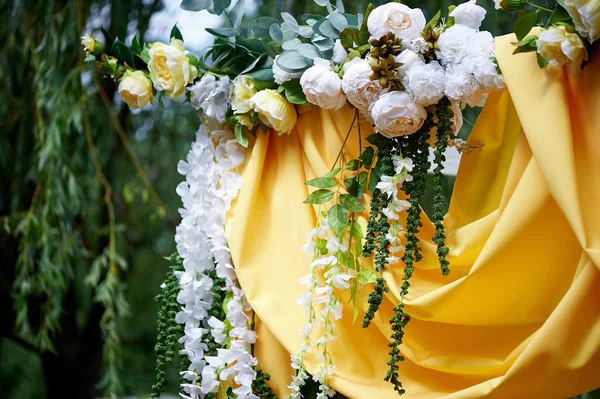 Arch Sarı kumaş ve çiçeklerle süslenmiş açık havada düğün töreni için. Ayrıntılar kapatın