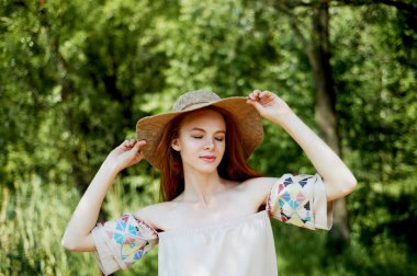 Sofistike Kızıl saçlı elbiseli bir kız bir basit keten, şapkalı bir ışık geniş ekledi. Model bak. Doğal güzellik. Sanatsal portre