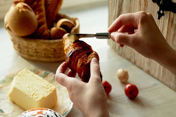 Light aesthetic French Breakfast. The girl is buttering a croissant with butter. В раме руки — стоковое фото