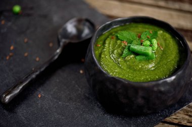 Çorba yeşil sebzeler, brokoli, fasulye, Bezelye püresi. Karanlık sofra kil bir rustik tarzda el yapımı. Vejetaryen yiyecekler. Yakın çekim