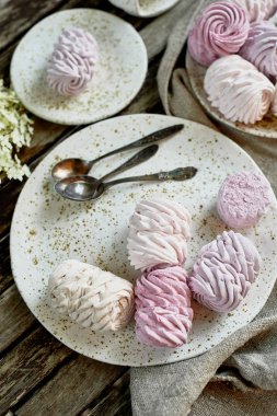 Temiz havada yaz çay. Tabaklarda hazırlanmış krema ve çay kaşığı vardır. Rustik tarzda gri çuval bezi ve el yapımı tabak parçasına hizmet