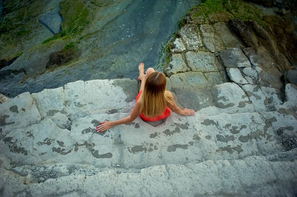 Cliff ve gazes bir kız oturuyor denize. Ücretsiz duygu ve sonsuzluk — Stok fotoğraf