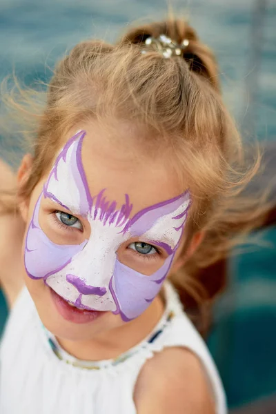 Bastante emocionante chica de ojos azules de 5 años con una pintura de la cara —  Fotos de Stock