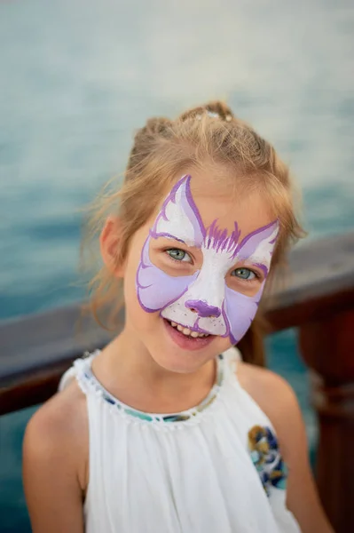 Bastante emocionante chica de ojos azules de 5 años con una pintura de la cara —  Fotos de Stock