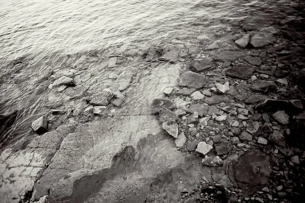 De structuur of een patroon van de stenen onder water. Rocky, rotsachtige kust — Stockfoto