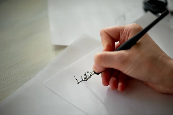 Eine Frauenhand schreibt mit Tinte, einem Füllfederhalter. Schreiben. der kreative Prozess der Entstehung eines Werkes, das Wort Liebe — Stockfoto