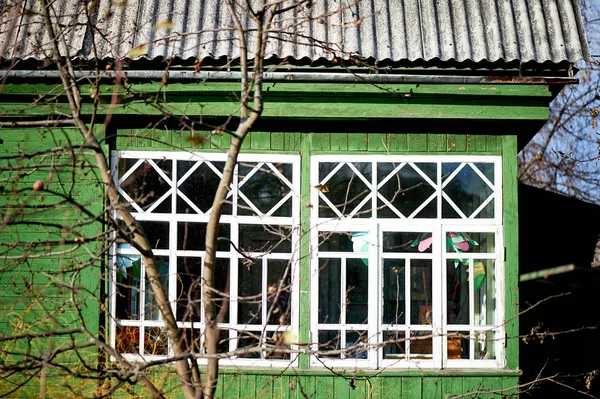 Starý zelený dřevěný dům s bílými okny. Prosklená veranda — Stock fotografie