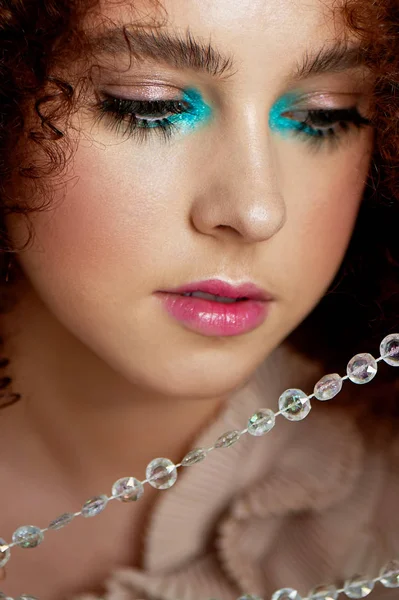 En flicka med lummiga lockigt hår. Nära fotograferade docka lösögonfransar. Docka makeup. — Stockfoto