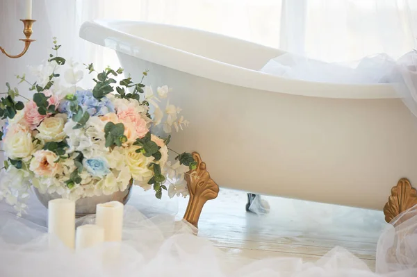 Bath on lions Golden paws.The atmosphere of romance and love. Light interior, chiffon, flowers.