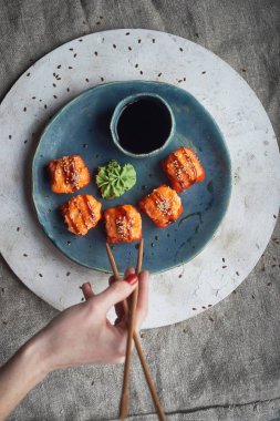Japon mutfağının el yapımı seramik üzerinde. Bir mavi kil tabak pişmiş sıcak rulo.