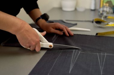 Ana kumaş keser. İç içe geçirme. Kumaş elbise kumaşı Beyaz tebeşir ile işaretlenmiş. Kesim ve dikiş