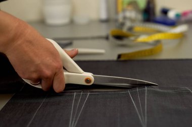 Ana kumaş keser. İç içe geçirme. Kumaş elbise kumaşı Beyaz tebeşir ile işaretlenmiş. Kesim ve dikiş