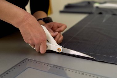 Ana kumaş keser. İç içe geçirme. Kumaş elbise kumaşı Beyaz tebeşir ile işaretlenmiş. Kesim ve dikiş