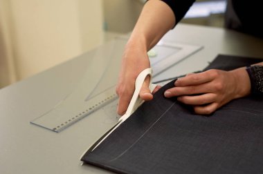 Ana kumaş keser. İç içe geçirme. Kumaş elbise kumaşı Beyaz tebeşir ile işaretlenmiş. Kesim ve dikiş