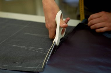 Ana kumaş keser. İç içe geçirme. Kumaş elbise kumaşı Beyaz tebeşir ile işaretlenmiş. Kesim ve dikiş