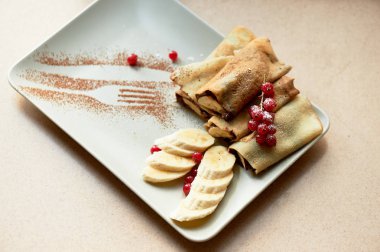 Çikolata yayıldı ve muz krep tatlı sıcak. Kuş üzümü ile dekore edilmiştir. Şekerli tatlı.