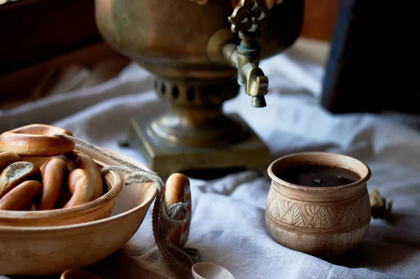 stock image Donut on a string.Traditional Russian pastries. Samovar and tea in an old clay mug.