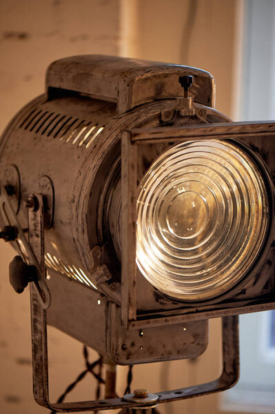 Old movie projector with a lens and a hot lamp.On a tripod.