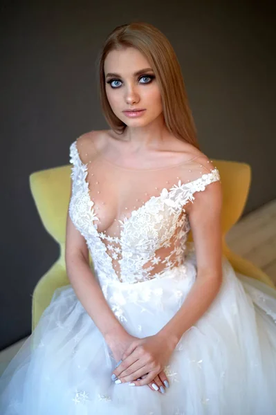 Retrato de una hermosa novia en un vestido de encaje.Maquillaje ojos humeantes, énfasis en los ojos. Cabello largo y fluido . — Foto de Stock