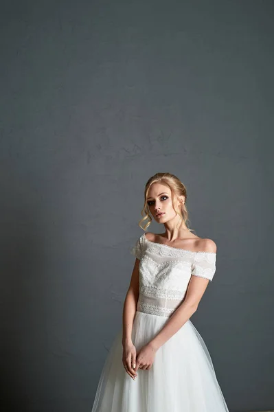 Una novia pequeña, rubia en un vestido de encaje.Cabello con rizos. Novia mañana . — Foto de Stock