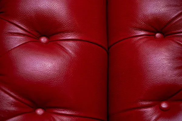 Le rembourrage en cuir rouge du canapé, rembourrage avec boutons.Texture . — Photo