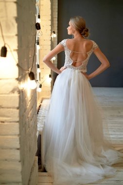 Gelinin zarif arkası. Pencereden dışarı bakıyorum. Saç modeli - Fransız tarzı zarif demet.