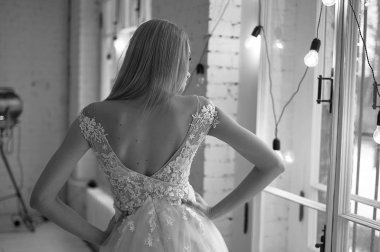 Gelinin zarif arkası. Pencereden dışarı bakıyorum. Saç modeli - Fransız tarzı zarif demet.