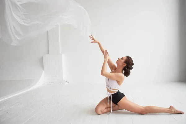 Gimnasta bailando con una película transparente en una pared blanca y piso.Gracia y estilo de vida saludable . —  Fotos de Stock