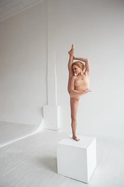 Hermosa bailarina de ballet posando en el estudio realizando la desviación en la espalda y apoyándose en un cubo grande —  Fotos de Stock