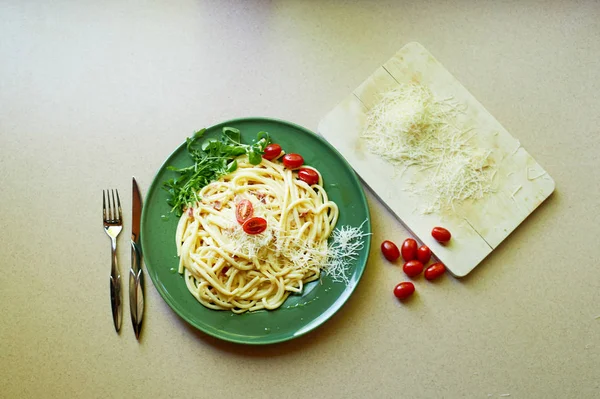 Pasta Carbonara with grated Parmesan cheese and cherry tomatoes, decorated with arugula.Italian lunch. — Stock Photo, Image