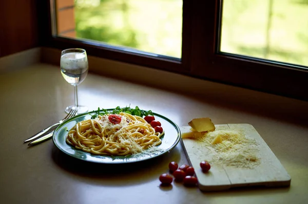 Pasta Carbonara z tartą parmezanem i pomidorami wiśniowym, ozdobiona arugula. Włoski obiad. — Zdjęcie stockowe